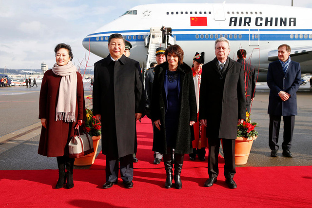 Chinese President Xi Jinping (2nd L) and his wife Peng Liyuan (L), Swiss President Doris Leuthard (2ndR) and her husband Roland Hausin listen to the national anthems during a welcome ceremony at the airport in Zurich, Switzerland January 15, 2017.  (KEYSTONE/REUTERS POOL/Arnd Wiegmann)..