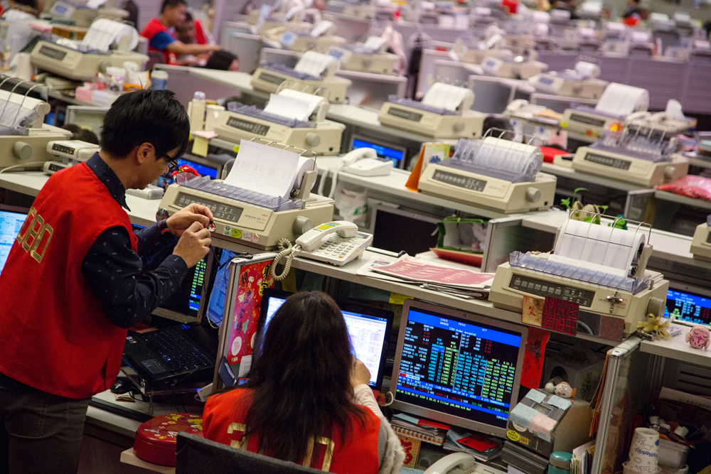 Traders work on the trading floor of the Hong Kong Stock Exchange during the first day of trading after Chinese New Year in Hong Kong, China, on Tuesday, Feb. 4, 2014. Hong Kong stocks tumbled on high volume, with the benchmark index poised to cap a 11 percent fall from a December peak, after weaker-than-expected manufacturing growth from the U.S. to China fueled a global equities rout. Photographer: Lam Yik Fei/Bloomberg