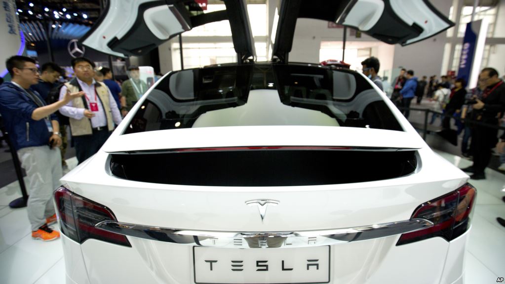 A visitor looks at a Tesla Model X on display at the Beijing International Automotive Exhibition in Beijing, Tuesday, April 26, 2016. (AP Photo/Mark Schiefelbein)