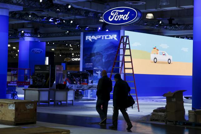 People walk near the Ford exhibit area of the New York International Auto Show at the Javits Center ahead of the event in New York March 30, 2015.
REUTERS/Shannon Stapleton