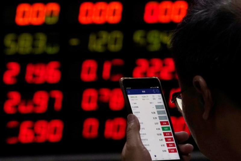 2018年6月20日，上海一家券商营业部，一名股民在看手机上的股票信息。REUTERS/Aly Song