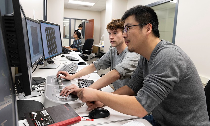 Nianshuang Wang, research associate, right, and Daniel Wrapp, graduate student, left, review cryo-EM images in the The Sauer Structural Biology Laboratory Monday Feb. 17, 2020 at The University of Texas at Austin.