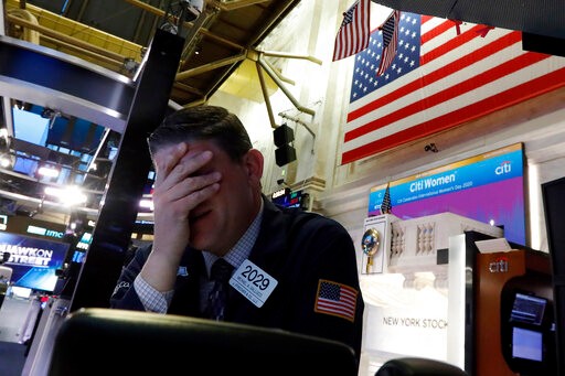 Trader Michael Gallucci prepares for the day's activity on the floor of the New York Stock Exchange, Monday, March 9, 2020. Trading in Wall Street futures has been halted after they fell by more than the daily limit of 5%. (AP Photo/Richard Drew)