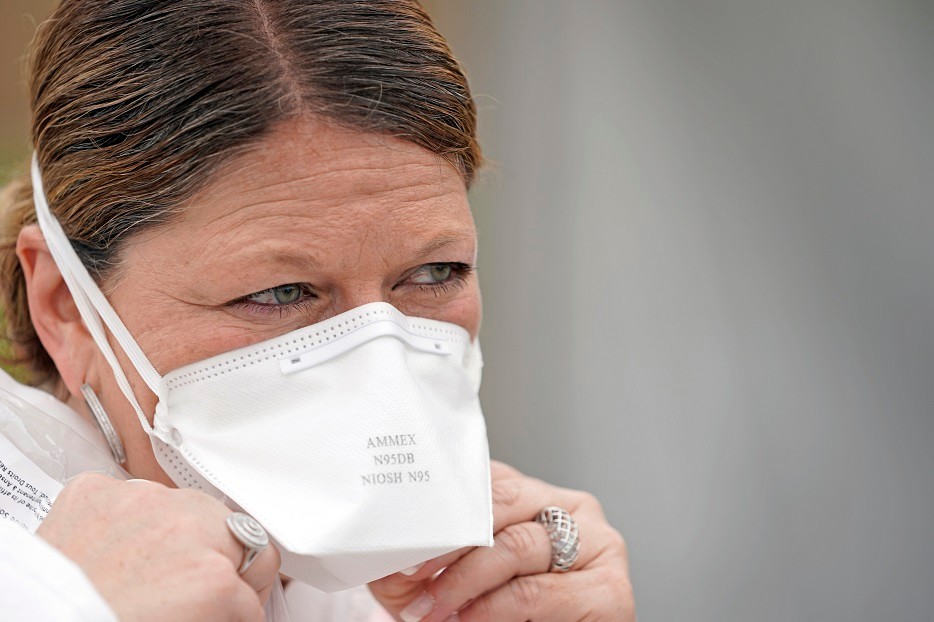 Nurse Yvette Laugere adjusts her N95 mask while working at a newly opened free Covid-19 testing site operated by United Memorial Medical Center Thursday, April 2, 2020, in Houston. The new coronavirus causes mild or moderate symptoms for most people, but for some, especially older adults and people with existing health problems, it can cause more severe illness or death. (AP Photo/David J. Phillip)
