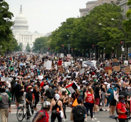 Demonstrators walk on Pennsylvania Avenue as they protest, Saturday, June 6, 2020, in Washington, over the death of George Floyd, a black man who was in police custody in Minneapolis. Floyd died after being restrained by Minneapolis police officers. (AP Photo/Andrew Harnik)