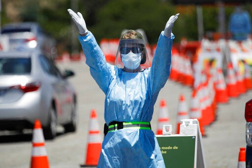 A worker directs traffic at a coronavirus testing site set up at Dodger Stadium Tuesday, May 26, 2020, in Los Angeles. (AP Photo/Marcio Jose Sanchez)