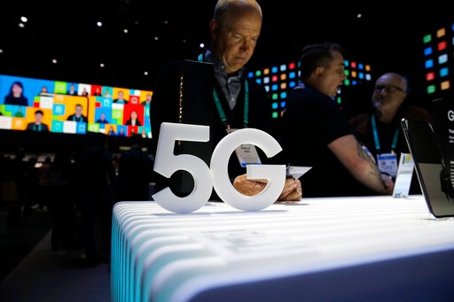 People loook at 5G phones at the Samsung booth during the CES tech show, Tuesday, Jan. 7, 2020, in Las Vegas. (AP Photo/John Locher)