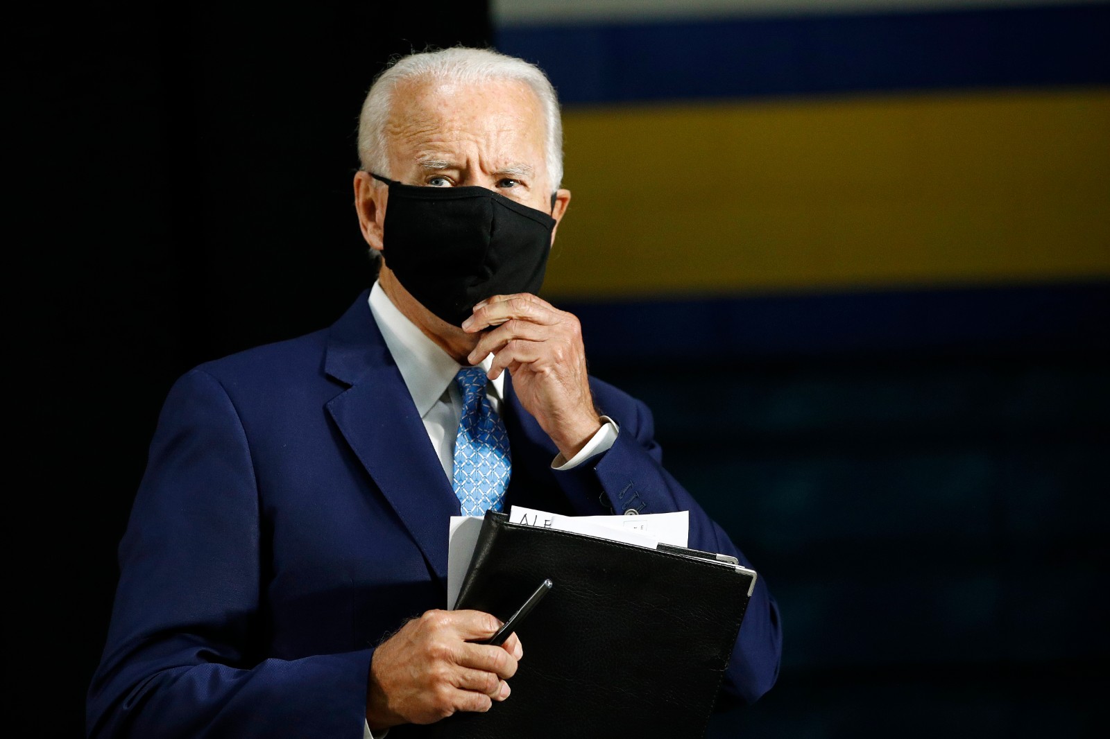 Democratic presidential candidate, former Vice President Joe Biden puts on a face mask to protect against the spread of the new coronavirus as he departs after speaking at Alexis Dupont High School in Wilmington, Del., Tuesday, June 30, 2020. (AP Photo/Patrick Semansky)