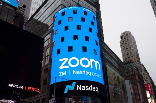 FILE - This April 18, 2019, file photo shows a sign for Zoom Video Communications ahead of the company's Nasdaq IPO in New York. Now that Zoom has emerged as one of the most popular ways to get together virtually while the coronavirus pandemic keeps people apart, the company is trying to build a more secure fortress around the billions of conversations occurring on its videoconferencing service daily. (AP Photo/Mark Lennihan, File)
