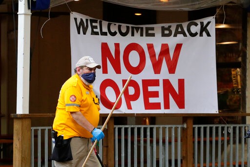A worker passes a sign at a restaurant along the River Walk that has reopened in San Antonio, Wednesday, May 13, 2020. Many restaurants and stores that were closed due to the COVID-19 pandemic have reopened with some restrictions. (AP Photo/Eric Gay)