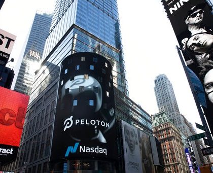 The Peloton logo is displayed, center, on the Nasdaq MarketSite, Thursday, Sept. 26, 2019 in New York's Times Square. (AP Photo/Mark Lennihan)