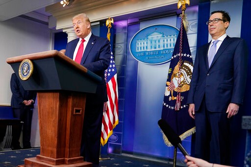 President Donald Trump speaks during a news briefing at the White House, Thursday, July 2, 2020, in Washington, as Treasury Secretary Stephen Mnuchin looks on. (AP Photo/Evan Vucci)
