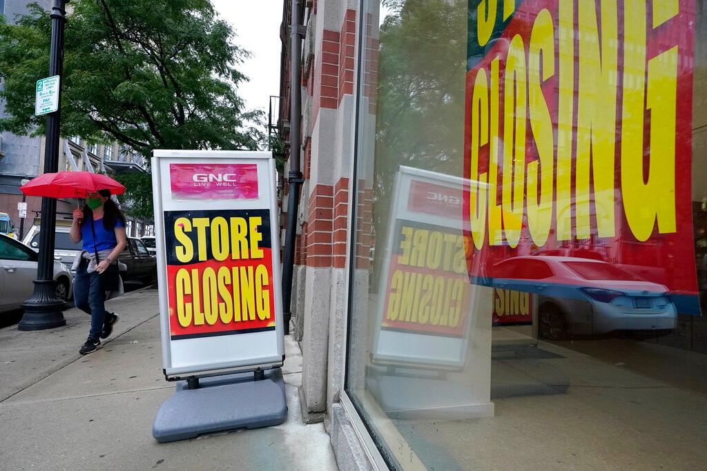 FILE - In this Sept. 2, 2020, file photo, a passerby walks past a business storefront with store closing signs in Boston. The U.S. unemployment rate dropped to 7.9% in September, but hiring is slowing and many Americans have given up looking for work, the government said Friday, Oct. 2, in the final jobs report before the voters decide whether to give President Donald Trump another term. (AP Photo/Steven Senne, File)