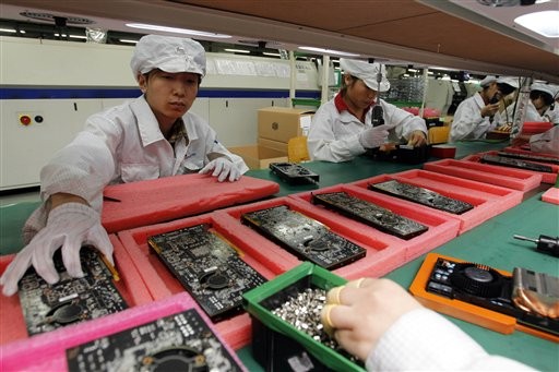 FILE - In this May 26, 2010 file photo, staff members work on the production line at the Foxconn complex in the southern Chinese city of Shenzhen. In new signs China's rapid rebound is slowing, the government said Tuesday, July 20, 2010 that growth in factory output and state company revenues is falling and exports will weaken in the second half of the year. (AP Photo/Kin Cheung, File)