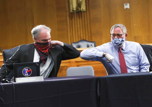Sen. Tim Kaine, D-Va., left, and Sen. Richard Burr, R-N.C., greet each other with an elbow bump before the Senate Committee for Health, Education, Labor, and Pensions hearing, Tuesday, May 12, 2020 on Capitol Hill in Washington. Dr. Anthony Fauci, director of the National Institute of Allergy and Infectious Diseases, is to testify before the committee.  (Win McNamee/Pool via AP)