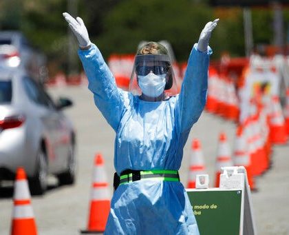 A worker directs traffic at a coronavirus testing site set up at Dodger Stadium Tuesday, May 26, 2020, in Los Angeles. (AP Photo/Marcio Jose Sanchez)