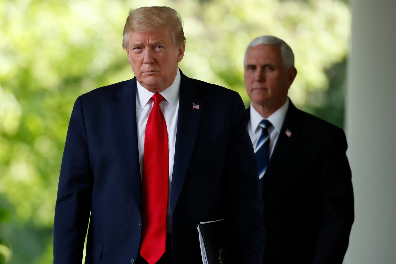 President Donald Trump and Vice President Mike Pence walk from the Oval Office to speak about the coronavirus in the Rose Garden of the White House, Monday, April 27, 2020, in Washington. (AP Photo/Alex Brandon)