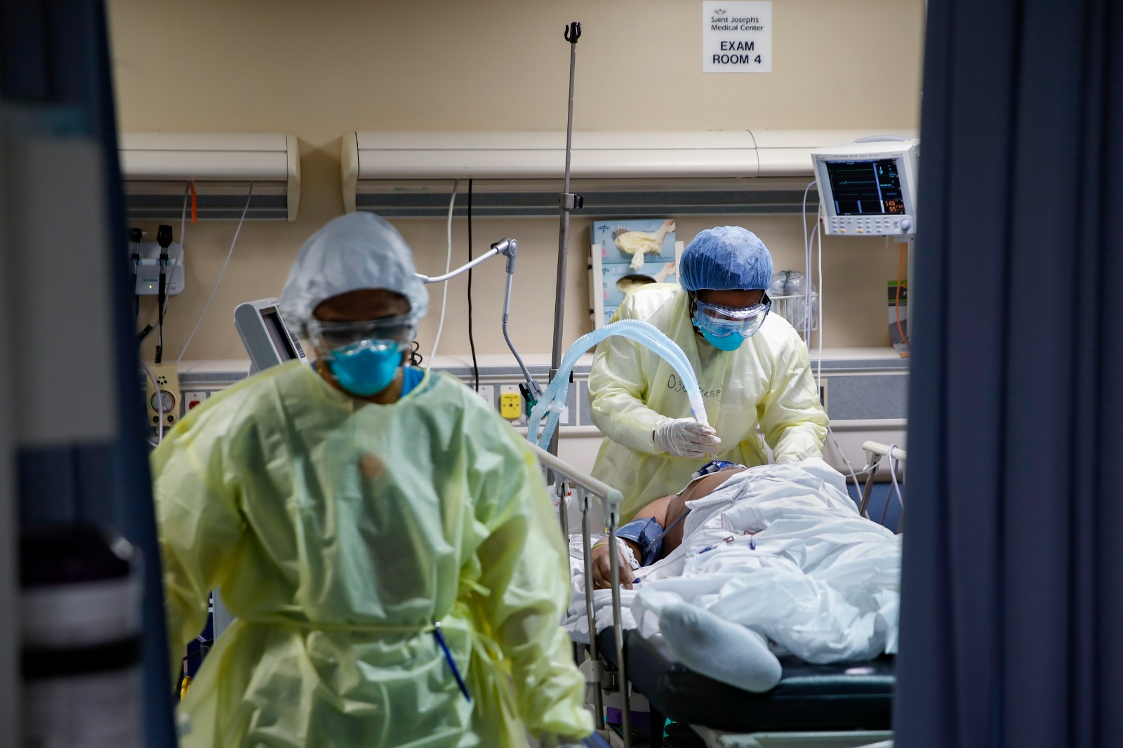 CORRECTS TO RESPIRATORY SPECIALIST FROM A NURSE - A respiratory specialist operates a ventilator for a patient with COVID-19 who went into cardiac arrest and was revived by staff, Monday, April 20, 2020, at St. Joseph's Hospital in Yonkers, N.Y. (AP Photo/John Minchillo)