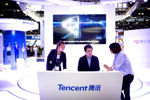 In this April 27, 2017, photo, staff members work at a booth for Chinese technology firm Tencent, makers of the messaging app WeChat, at the Global Mobile Internet Conference (GMIC) in Beijing. President Donald Trump on Thursday, Aug. 6, 2020, ordered a sweeping but unspecified ban on dealings with the Chinese owners of consumer apps TikTok and WeChat, although it remains unclear if he has the legal authority to actually ban the apps from the U.S. (AP Photo/Mark Schiefelbein)