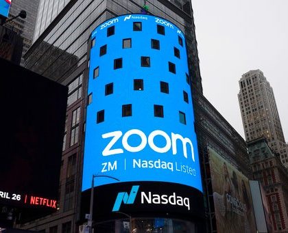 FILE - This April 18, 2019, file photo shows a sign for Zoom Video Communications ahead of the company's Nasdaq IPO in New York. Now that Zoom has emerged as one of the most popular ways to get together virtually while the coronavirus pandemic keeps people apart, the company is trying to build a more secure fortress around the billions of conversations occurring on its videoconferencing service daily. (AP Photo/Mark Lennihan, File)