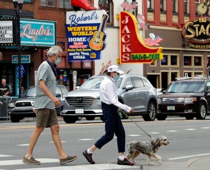 People wear masks as they cross Broadway Tuesday, June 30, 2020, in Nashville, Tenn. The Nashville Health Department has put in place a mask mandate to help battle the spread of the coronavirus. (AP Photo/Mark Humphrey)