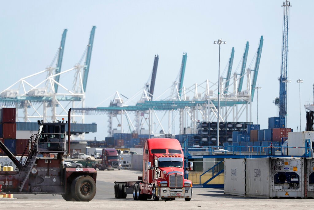 FILE - In this Feb. 14, 2020 file photo,  a truck leaves the docks at PortMiami in Miami.  The U.S. economy shrank at an alarming annual rate of 31.7% during the April-June quarter as it struggled under the weight of the viral pandemic, the government estimated Thursday, Aug. 27.  (AP Photo/Wilfredo Lee, File)
