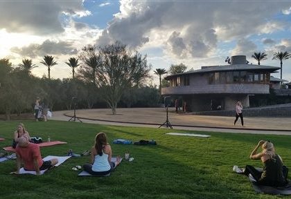 In this Tuesday, Sept. 22, 2015 photo, Participants get ready for a free yoga class outside the David and Gladys Wright House in Phoenix.  The Frank Lloyd Wright-designed Phoenix home will temporarily cease hosting daily tours and special events after May 7. Operators want to focus on finding organizations to collaborate on preservation and operations plans. (AP Photo/Terry Tang)