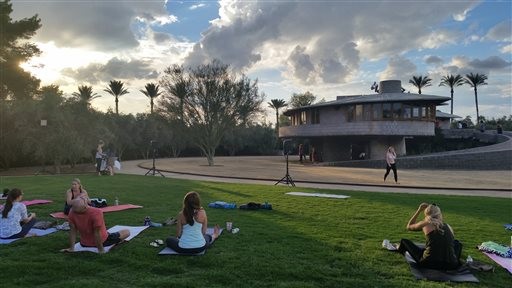 In this Tuesday, Sept. 22, 2015 photo, Participants get ready for a free yoga class outside the David and Gladys Wright House in Phoenix.  The Frank Lloyd Wright-designed Phoenix home will temporarily cease hosting daily tours and special events after May 7. Operators want to focus on finding organizations to collaborate on preservation and operations plans. (AP Photo/Terry Tang)